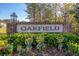 Welcoming Oakfield community entrance sign with brick columns, lush landscaping, and decorative lanterns at 2109 Rowan Rd, Johns Island, SC 29455