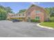 A two-story building with brick and yellow siding, covered porches, ample parking and a car visible at 2150 Spoleto Ln # H2, North Charleston, SC 29406