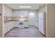 Functional kitchen with white cabinets, gray floors, and a refrigerator creating a clean and efficient space at 2150 Spoleto Ln # H2, North Charleston, SC 29406