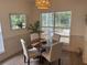 Dining area with a wood table, upholstered chairs, modern light fixture, and a large window at 2204 Andover Way, Mount Pleasant, SC 29466