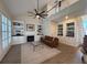 Open living room featuring a fireplace, built-in shelves, large windows, and a ceiling fan at 2204 Andover Way, Mount Pleasant, SC 29466