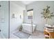 Bright bathroom with a freestanding tub, shower, decorative rug, and plant accent at 2431 Settlers St, Charleston, SC 29492