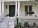Charming home entrance featuring a green door, white pillars, and a well-manicured garden at 2431 Settlers St, Charleston, SC 29492