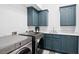 Updated laundry room has gray-blue cabinets, a sink, and modern washer/dryer at 2431 Settlers St, Charleston, SC 29492