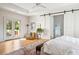 Bright main bedroom with outdoor access to a balcony, barn doors to the bathroom, and lovely hardwood floors at 2431 Settlers St, Charleston, SC 29492