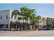 Street view of the building's storefronts with awnings, palm trees, and parked cars at 2431 Settlers St, Charleston, SC 29492