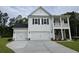 Charming two-story home with a three-car garage, white siding, and a cozy front porch at 251 Darby Meadow Ln, Ridgeville, SC 29472