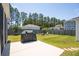 Backyard with a concrete patio featuring a grill and chairs with fire pit, perfect for outdoor entertaining at 262 Great Lawn Dr, Summerville, SC 29486