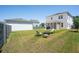 A spacious backyard with a fire pit and seating area, complemented by a well-maintained lawn and privacy fence at 262 Great Lawn Dr, Summerville, SC 29486