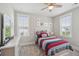 Comfortable bedroom with a ceiling fan, two windows with blinds and a bed with colorful striped bedding at 262 Great Lawn Dr, Summerville, SC 29486