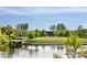 Beautiful outdoor community space with grassy area, trees, landscaping, and a small lake on a sunny day at 262 Great Lawn Dr, Summerville, SC 29486