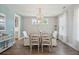 Dining room with stylish chandelier, wood floors, light blue accent wall and adjacent kitchen at 262 Great Lawn Dr, Summerville, SC 29486