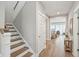 Entryway view showcasing hardwood floors, staircase, and a glimpse into a sunlit living area at 262 Great Lawn Dr, Summerville, SC 29486