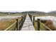 Picturesque boardwalk view surrounded by lush marshland and calm waters, offering a tranquil escape into nature at 2705 Parkers Landing Rd, Mount Pleasant, SC 29466