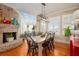 Charming dining room with a modern chandelier, brick fireplace, bright windows, and stylish decor at 2705 Parkers Landing Rd, Mount Pleasant, SC 29466