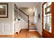 Inviting foyer with staircase, hardwood floors, wainscoting, and a stylish storage chest at 2705 Parkers Landing Rd, Mount Pleasant, SC 29466