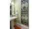Elegant powder room featuring a pedestal sink, decorative metal art piece, and light green painted walls at 2705 Parkers Landing Rd, Mount Pleasant, SC 29466