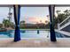 Tranquil pool view framed by elegant blue curtains and lush greenery offers a private oasis at 2705 Parkers Landing Rd, Mount Pleasant, SC 29466