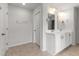 Bathroom with double sink vanity, white cabinets, tile flooring, and a door, illuminated by modern lighting at 2746 Sunrose Ln, Johns Island, SC 29455