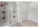 Bathroom with glass shower featuring built-in shelves and tile flooring, next to a white door at 2746 Sunrose Ln, Johns Island, SC 29455