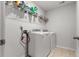 Functional laundry area with full-size washer, dryer, and practical shelving for supplies at 2746 Sunrose Ln, Johns Island, SC 29455