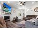 Cozy living room with a fireplace, ceiling fan, dark floors, and a television at 2746 Sunrose Ln, Johns Island, SC 29455