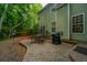 View of backyard patio, with furniture and grill, and of the house's green exterior at 3031 Ellington Dr, Summerville, SC 29485