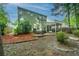 Green two-story house backyard with a cozy screened-in porch and patio surrounded by lush landscaping at 3031 Ellington Dr, Summerville, SC 29485