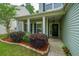 Inviting front porch with black door, white columns, shutters and vibrant landscaping at 3031 Ellington Dr, Summerville, SC 29485