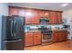Kitchen with stainless steel appliances, dark wood cabinets, and light granite countertops on hardwood floors at 3031 Ellington Dr, Summerville, SC 29485