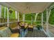 Relaxing screened porch with comfortable seating, ceiling fan, and view of the wooded backyard at 3031 Ellington Dr, Summerville, SC 29485