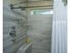 Modern shower with gray wood-look tile, shower caddy, and rainfall shower head at 3031 Ellington Dr, Summerville, SC 29485