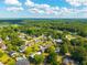 Aerial view of a residential area with pools, lush trees, and clear blue skies at 305 Whitewood Ct, Moncks Corner, SC 29461
