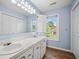 Well-lit bathroom with double sinks, white cabinetry, and natural light from a window at 305 Whitewood Ct, Moncks Corner, SC 29461