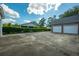 Long concrete driveway to two garages, lined by manicured hedges at 305 Whitewood Ct, Moncks Corner, SC 29461