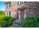 Close-up of a brick home's front entrance with a red door and manicured shrubs at 305 Whitewood Ct, Moncks Corner, SC 29461