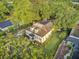 Aerial view of a charming two-story home featuring a red-accented porch and a well-manicured lawn surrounded by lush trees at 318 N Magnolia St, Summerville, SC 29483