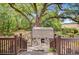 Back yard with large tree, patio with seating, and lush landscaping, providing privacy and shade at 318 N Magnolia St, Summerville, SC 29483