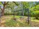 Back yard with lush landscaping, mature trees, and a patio with seating at 318 N Magnolia St, Summerville, SC 29483