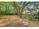 Expansive backyard with a large shade tree, mature landscaping, and a seating area with a canopy at 318 N Magnolia St, Summerville, SC 29483