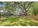 Lush backyard with mature trees, a patio set under a pergola, and a well-maintained lawn at 318 N Magnolia St, Summerville, SC 29483