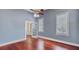 A blue bedroom with hardwood floors, two windows, and an open door, offering a bright and airy feel at 318 N Magnolia St, Summerville, SC 29483