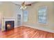 Spacious bedroom with a fireplace, hardwood floors, a ceiling fan, and large windows providing ample natural light at 318 N Magnolia St, Summerville, SC 29483
