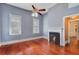A blue bedroom featuring hardwood floors, two windows, and a charming fireplace, creating a cozy atmosphere at 318 N Magnolia St, Summerville, SC 29483