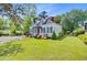 Charming two-story home with mature landscaping, red door, and a red chimney at 318 N Magnolia St, Summerville, SC 29483