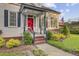 Inviting front porch with detailed trim and a striking red door framed by lush greenery at 318 N Magnolia St, Summerville, SC 29483