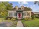 Beautifully landscaped front yard leading to a home with dormer windows and an inviting red door at 318 N Magnolia St, Summerville, SC 29483