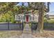 Charming home exterior with a red door, black shutters, and a lush magnolia tree at 318 N Magnolia St, Summerville, SC 29483