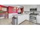 Charming kitchen with an island, stainless steel appliances, and red accent wall, offering an inviting cooking space at 318 N Magnolia St, Summerville, SC 29483