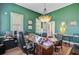 A cozy office with green walls, hardwood floors, and a large wooden desk, illuminated by a unique chandelier at 318 N Magnolia St, Summerville, SC 29483